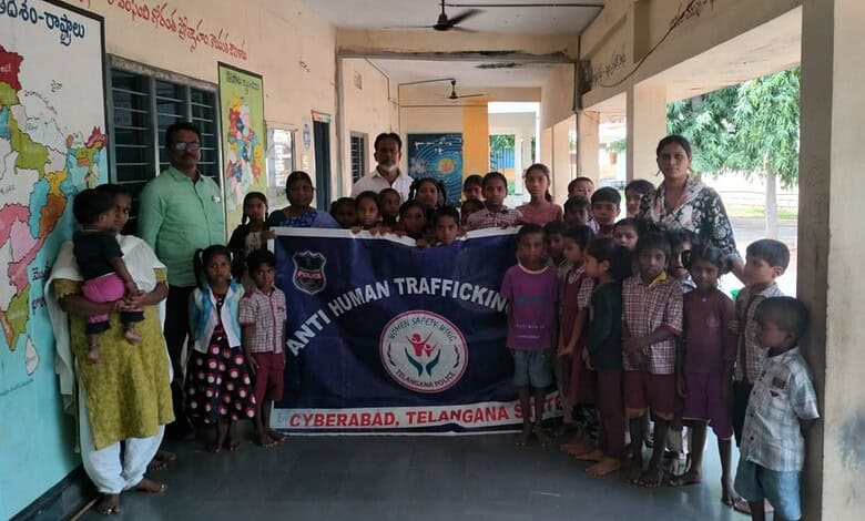 Group of children and adults holding a banner against human trafficking in Hyderabad, Telangana.