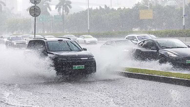 Cars driving through flooded street during heavy rain in Southern China.