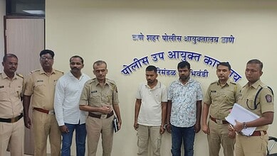 Group of police officers and civilians standing in front of a wall with Marathi text.