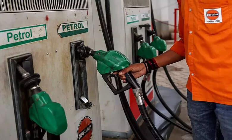 Person refueling vehicle with petrol at a petrol station, focus on fuel nozzle and pump.