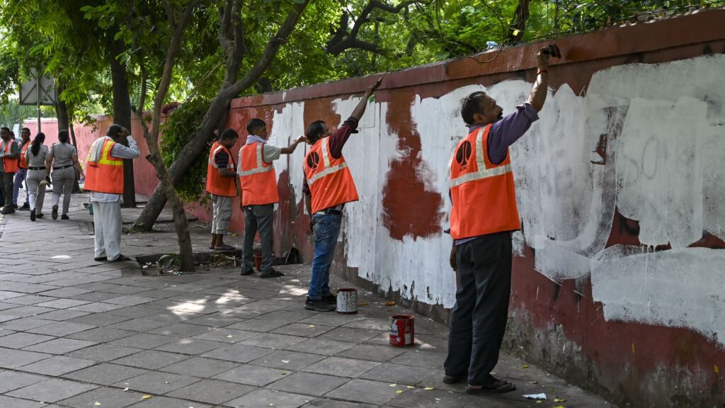 Volunteers painting a wall during a community service event in a park.