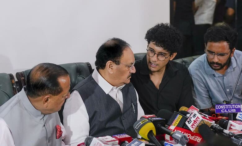 CJP with officials during a press conference, surrounded by microphones and media representatives.