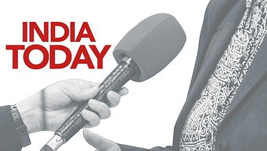 Close-up of a person holding a microphone during an interview or press conference.