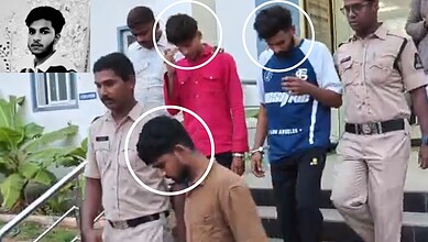 Group of young men and police officers outside a building, some looking at their phones.