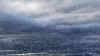 Dark stormy sky with heavy rain and thick clouds over the landscape.