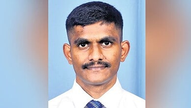 Portrait of a young man in a white shirt with a serious expression.