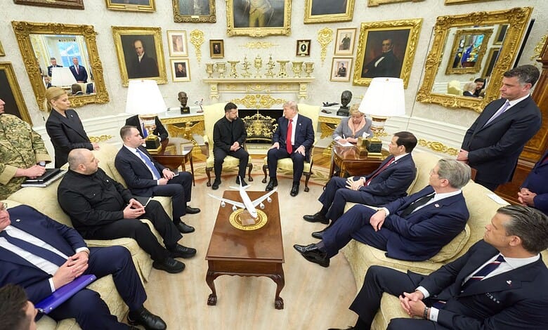 U.S. President Trump and Ukrainian President Zelenskyy meet with officials in a decorated room.