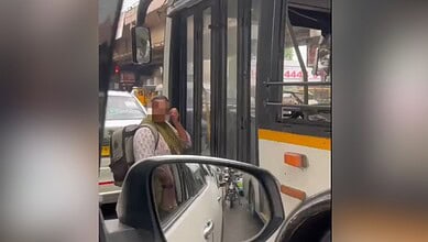 Woman passenger waits outside RTC bus as driver refuses to open door, causing controversy.