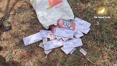 Abandoned voter ID cards scattered on the ground in Hyderabad.