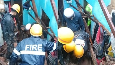 Rescue operation at a collapsed house in Mangaluru after heavy rain, with firefighters and rescue workers.