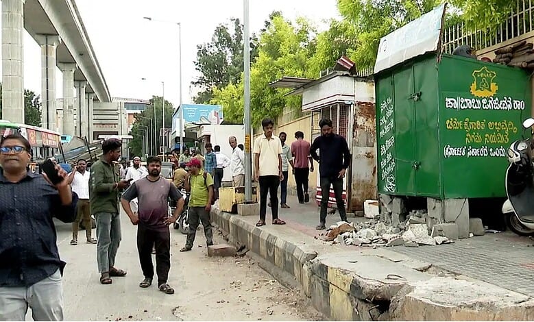 Footpath encroachment removal drive in Bengaluru with people and debris present.