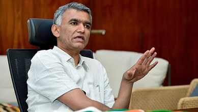 Bengaluru minister speaking during a press conference about property tax issues.