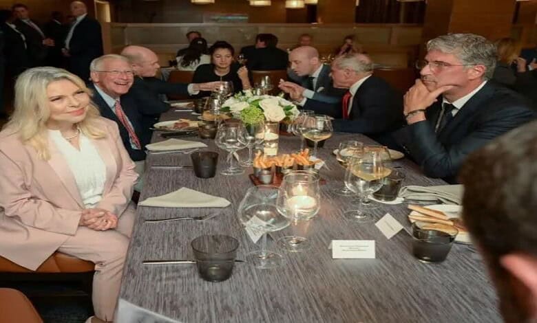 Business meeting with diverse professionals around a table in a formal setting.