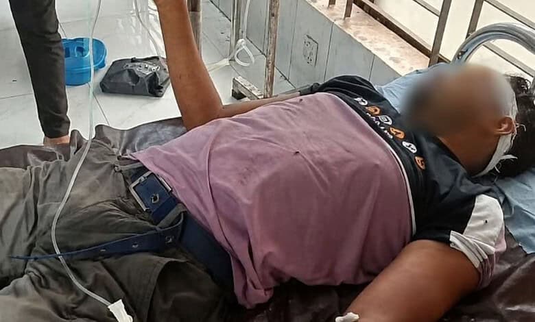 Unconscious man with oxygen mask lying on hospital bed in Bangladesh.