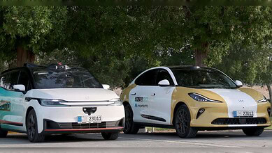 Two self-driving cars displaying Abu Dhabi's new blue autonomous vehicle licence plates.
