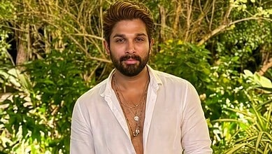 Allu Arjun in a white shirt with a lush green background, looking at the camera.