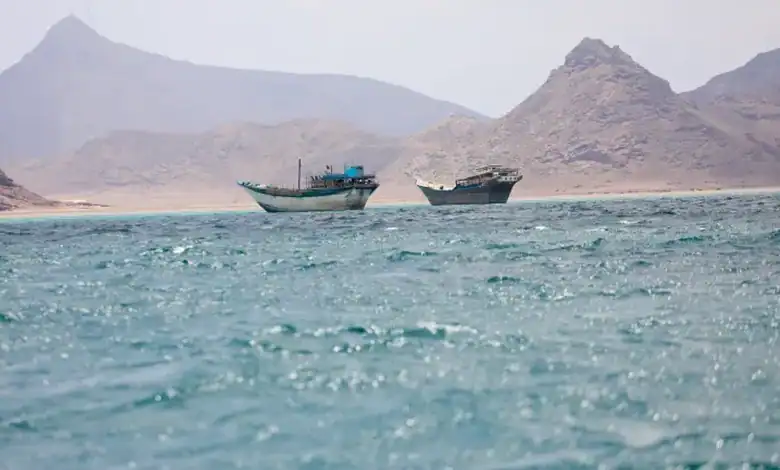 Two boats floating in the Red Sea with mountains in the background.