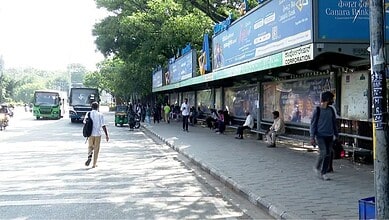 Bus stop near traffic signals in Bengaluru with people waiting and walking nearby.