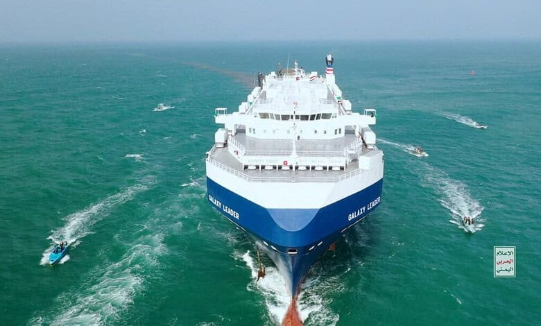 Large cargo ship sailing through the Red Sea near Yemen, with smaller boats around it.