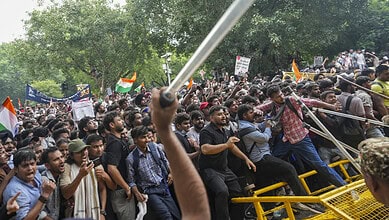Large crowd of protesters gathered with flags and banners during a demonstration.