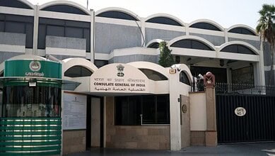 Indian Consulate Dubai building with signage and security gate for NRI certificate services.