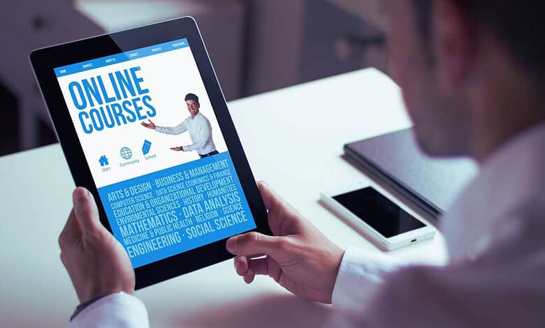 Person holding a tablet displaying online courses related to education and skills development.