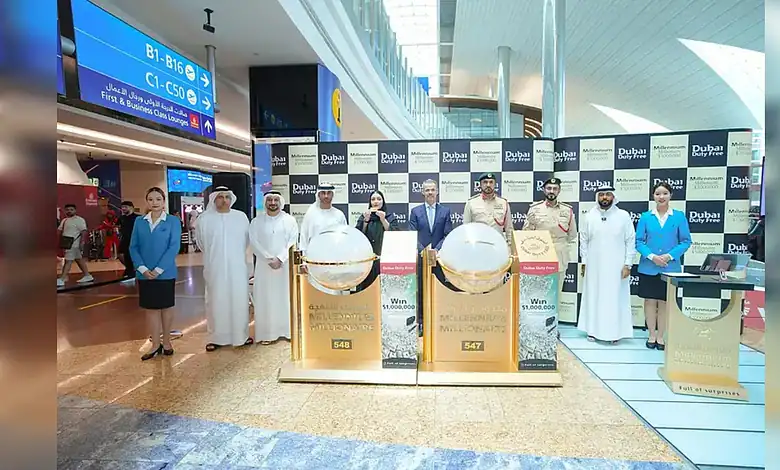 Officials pose beside the Millennium Millionaire draw machines during the Dubai Duty Free draw at Dubai International Airport.