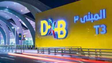 Dubai airport T3 entrance with bright yellow wall and illuminated signage for travellers.