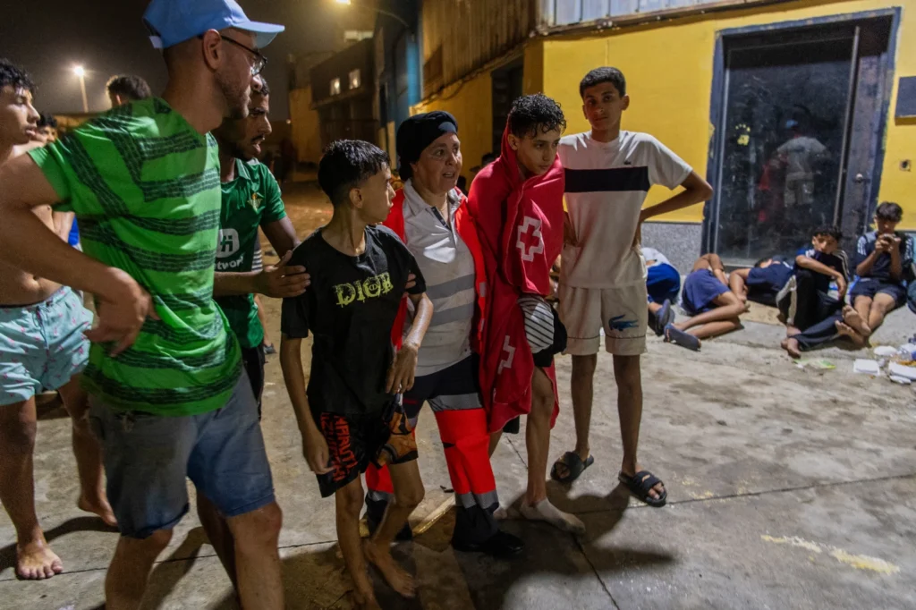 Emergency workers assist a migrant at a temporary shelter in Ceuta.