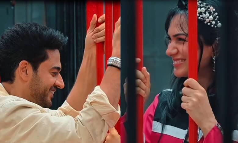 Gaurav Khanna and Akanksha smiling at each other behind red bars.