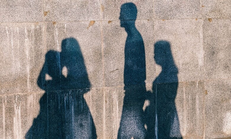 Silhouettes of three girls walking on a wall in Nagpur, India, during daytime.