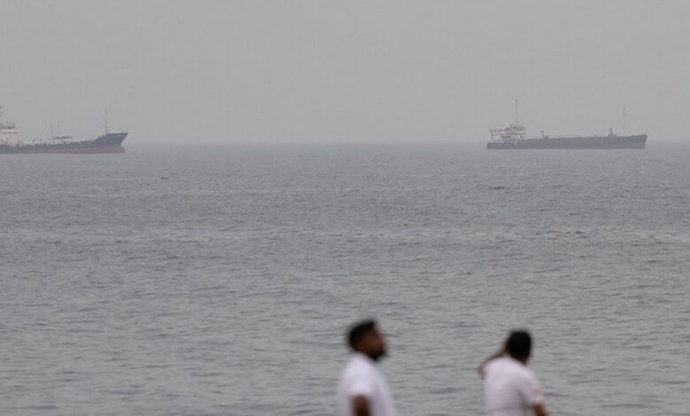 Two merchant vessels anchored in open Gulf waters with the sea stretching to the horizon.