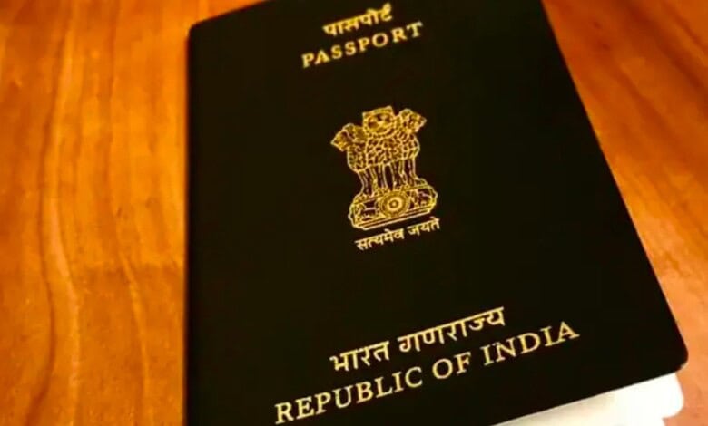Close-up of Indian passport with emblem and text on cover, on wooden surface.