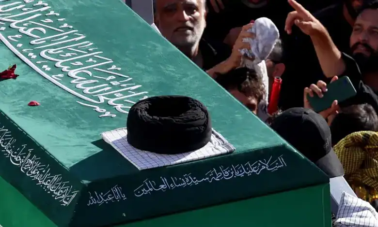 Large crowd gathers around Khamenei's coffin during funeral in Iran, with people paying respects and some.