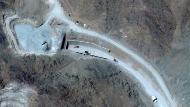 Aerial view of a mining site on Pickaxe Mountain in Iran with vehicles and infrastructure.
