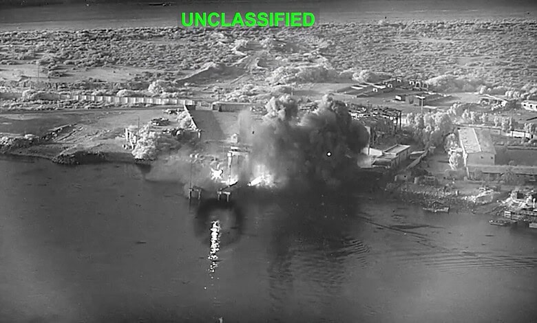 Explosive blast and smoke rising from a bridge during a US airstrike against Iran.