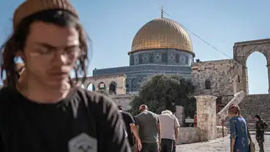 People visiting Al-Aqsa Mosque with the golden dome visible in the background.