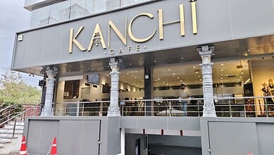 Exterior of Kanchi Cafe with modern design and signage in a busy area.