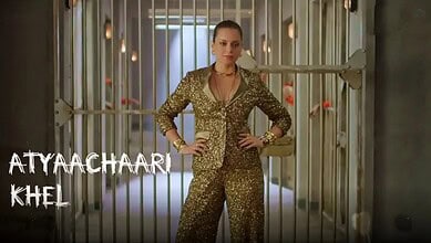 Kangana Ranaut in a gold sequined suit standing confidently in a corridor with bars.