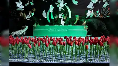 People gather around a coffin during a funeral procession in Tehran with red tulips in the foreground.
