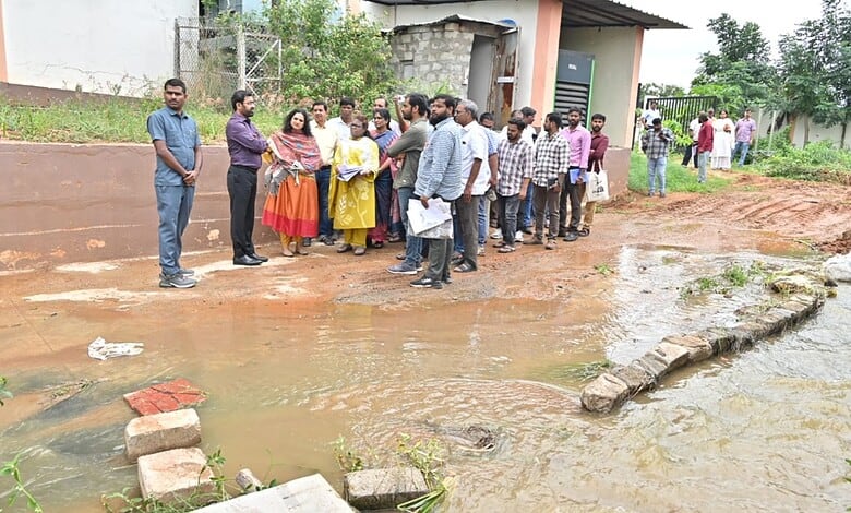 Group of residents and officials examining sewage entering pond in Hyderabad.