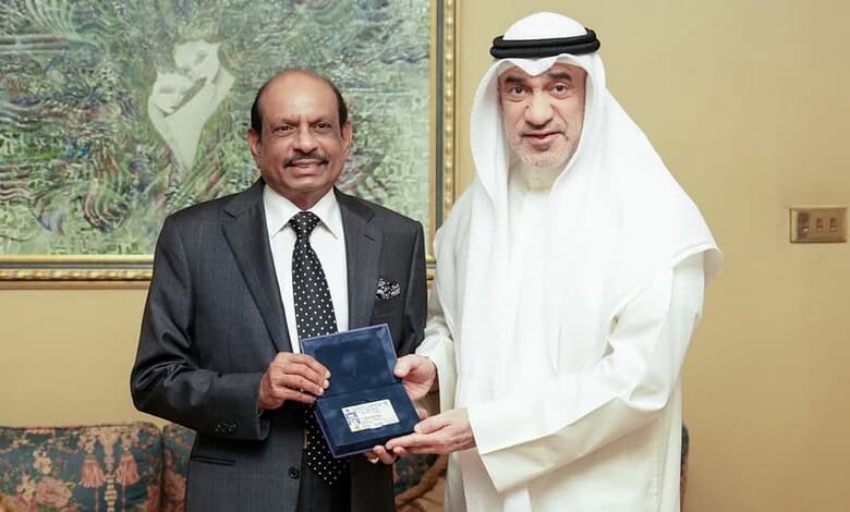 Yusuff Ali receiving Kuwait's Golden Residency from an official in traditional attire.