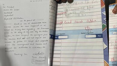Close-up of a student's homework notebook with handwritten notes and teacher's signature.
