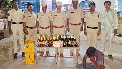Police officers displaying seized alcohol bottles and cash at a public event.