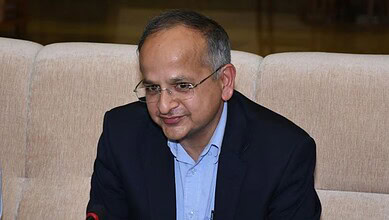 Indian official in formal attire during a press conference or meeting.
