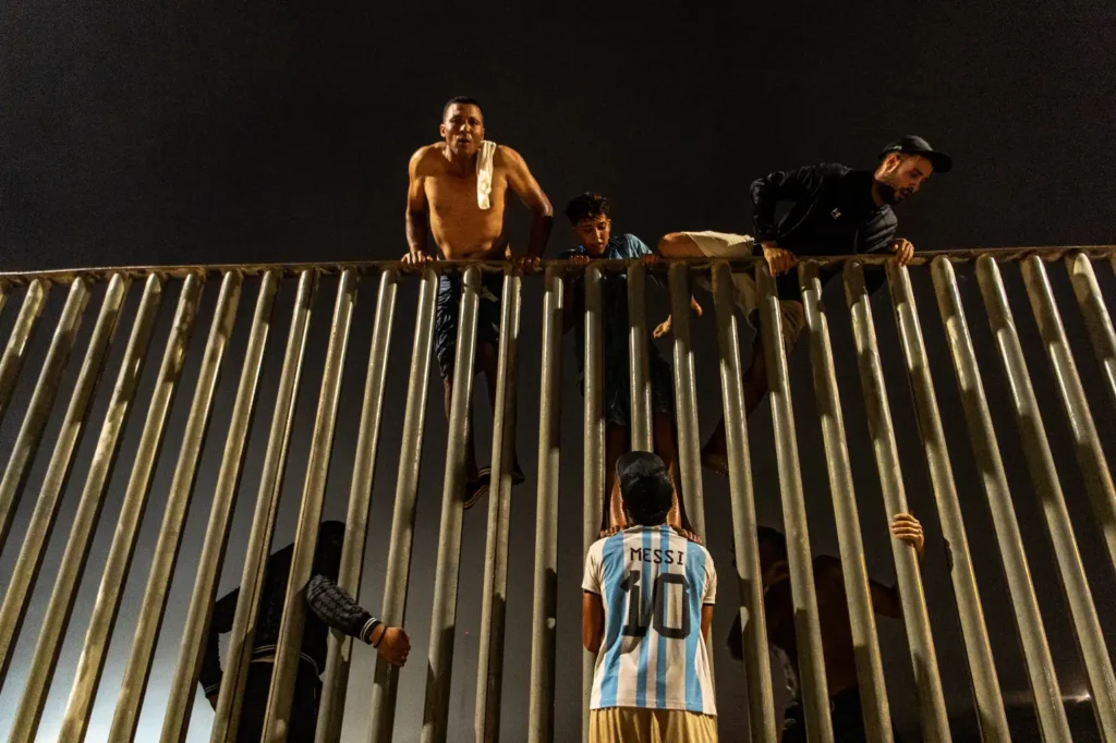 Migrants climb the border fence separating Morocco from Spain's Ceuta.