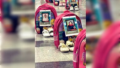 Memorial display with photographs of children at Tehran airport for Minab memorial.