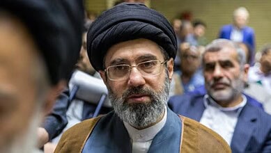 Ali Khamenei with a black turban and glasses at a memorial gathering.