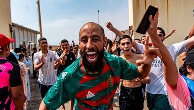 Group of migrants celebrating after crossing into Spain from Morocco at Ceuta border.
