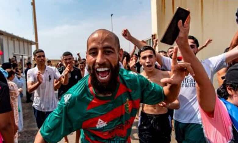 Group of migrants celebrating after crossing into Spain from Morocco at Ceuta border.
